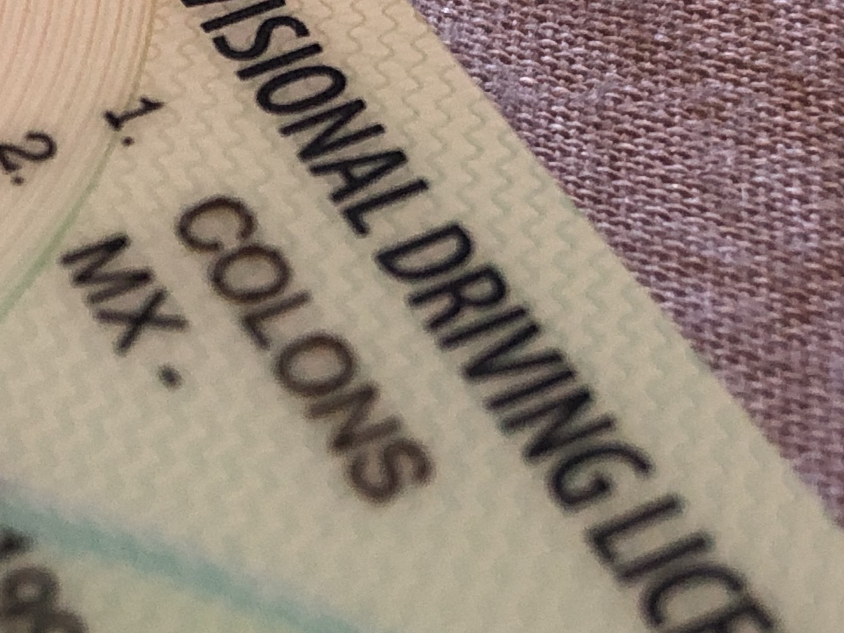Extreme close-up of a UK drivers license for someone with the name "MX - COLONS"